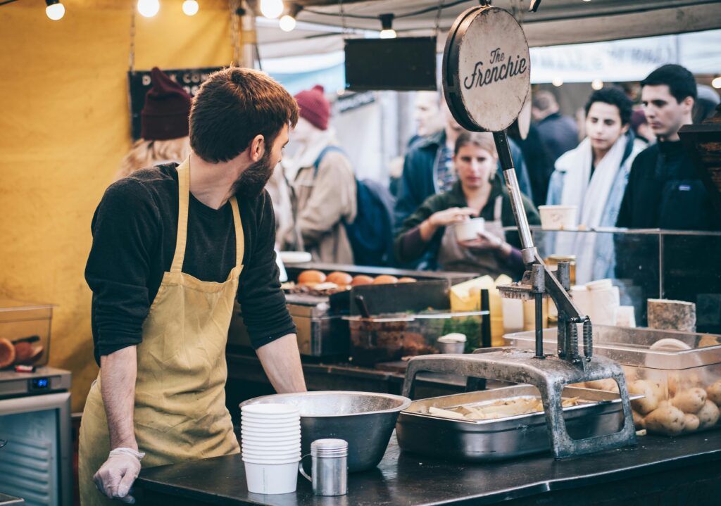 pexels photo 375889 375889 Dynamic scene of a street food vendor working in a busy market, engaging with diverse customers.